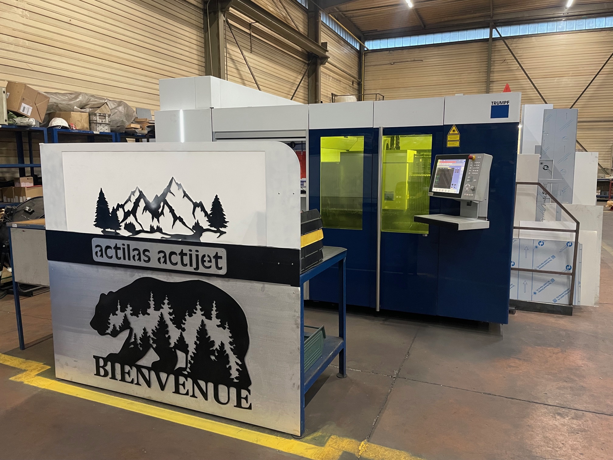 Machine de découpe laser Trumpf TruLaser 3040 derrière le panneau Bienvenue Actilas Actijet